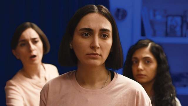 Three sibling looking feminine individuals in front of a blue background