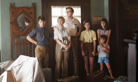 Family standing awkwardly in what seems to be a new home.